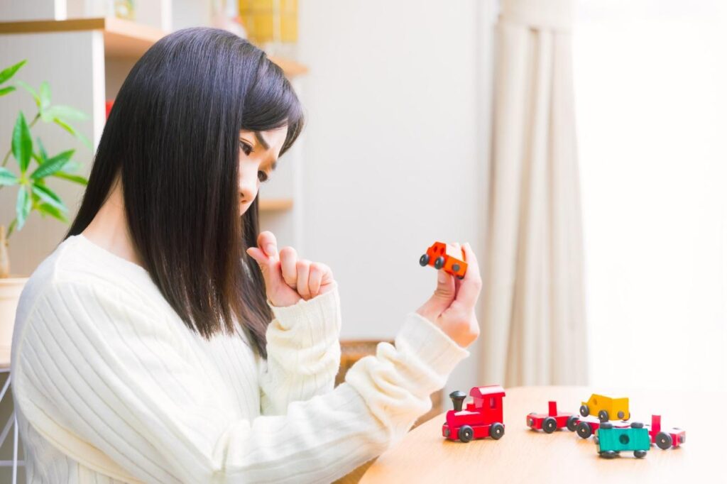 車のおもちゃを持って悩む女性