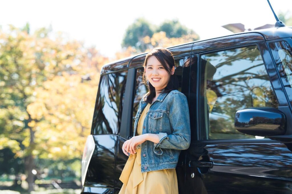 黒い車に寄りかかる女性