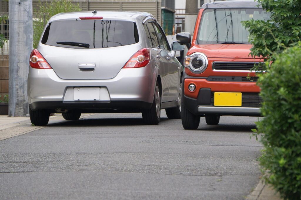 狭い道ですれ違っている2台の自動車