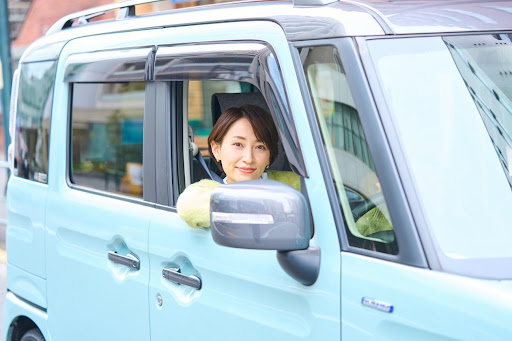 水色の軽自動車に乗った女性