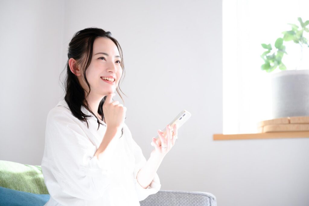 スマホを見て車を選ぶ女性