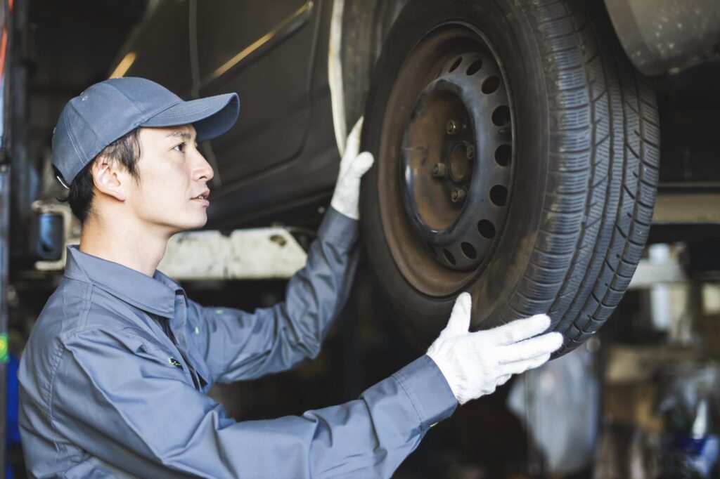 タイヤの検査を受けている自動車と検査員