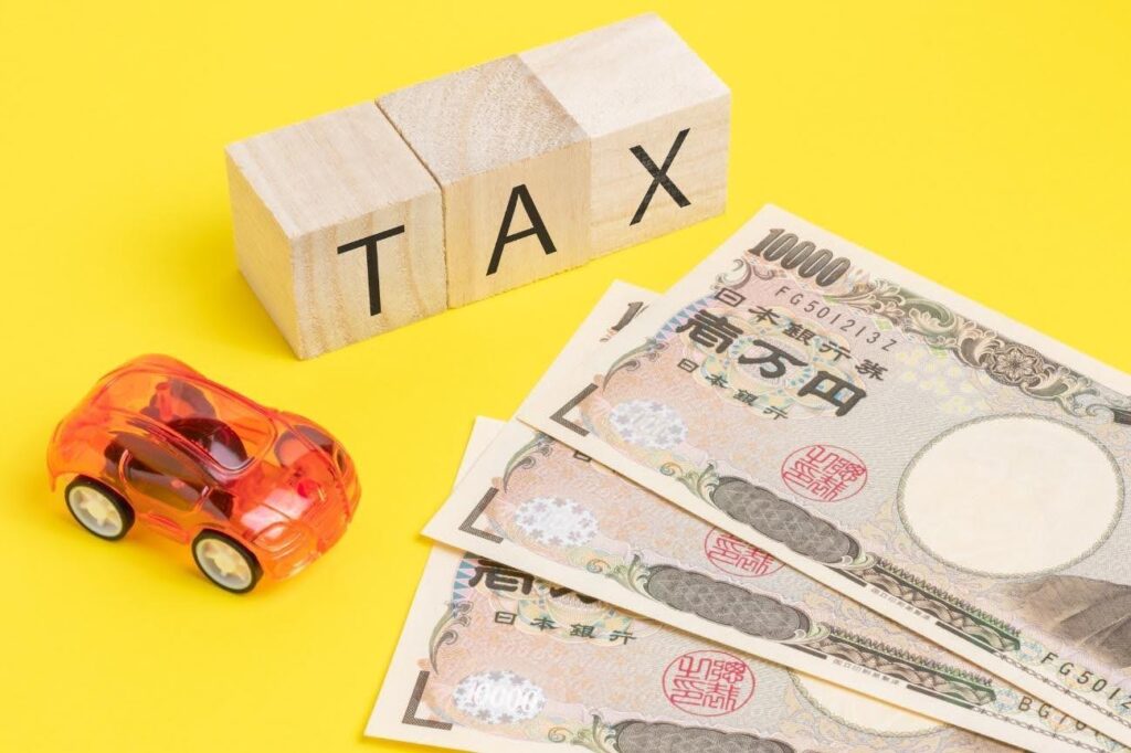 TAXと書かれた積み木とお札と車のおもちゃ