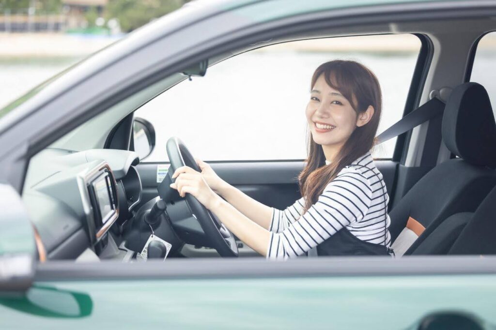 緑の車を運転する女性