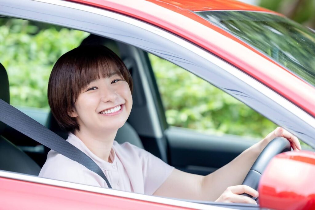 車を運転する笑顔の若い女性