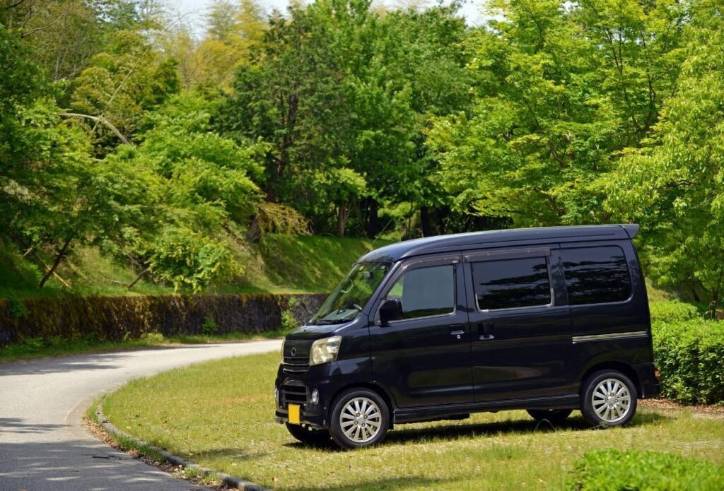 公園に停車する黒色の軽バン