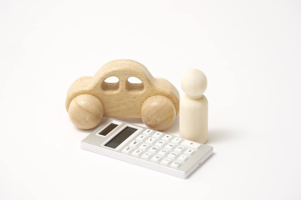 木製の車と人型のおもちゃと計算機
