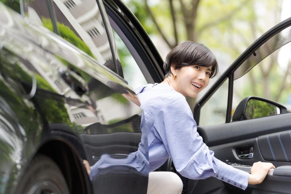 車に乗り込む笑顔の若い女性