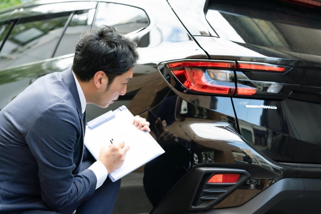 車の査定をするビジネスマン