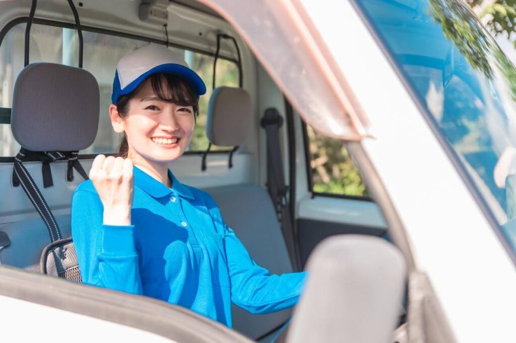 運転席でガッツポーズを取る青い服の女性