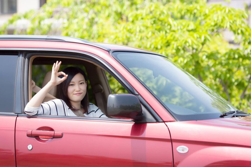 車を運転する笑顔の若い女性