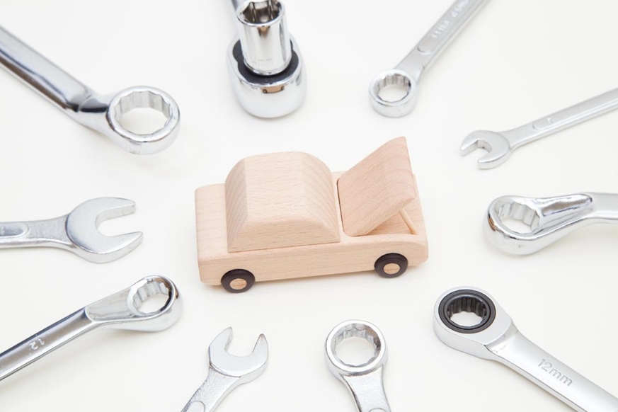 木製の車の模型とモンキーレンチ