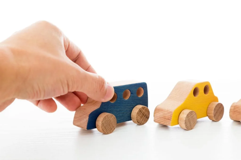 黄色や青の木製の車をつかむ様子