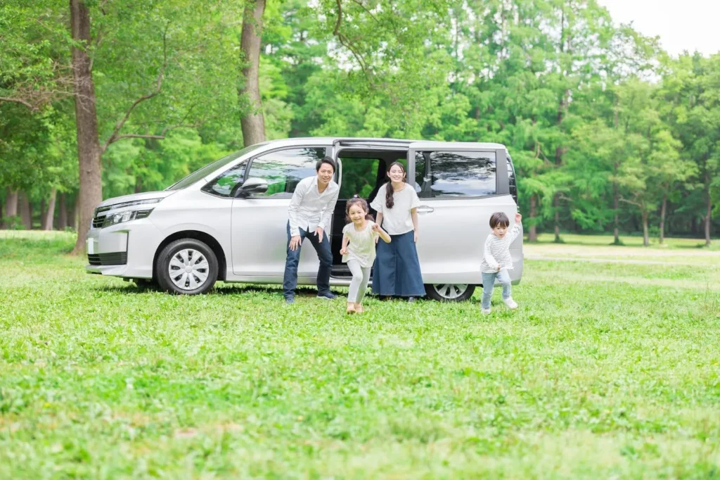 ミニバンを降りて駆け出す家族