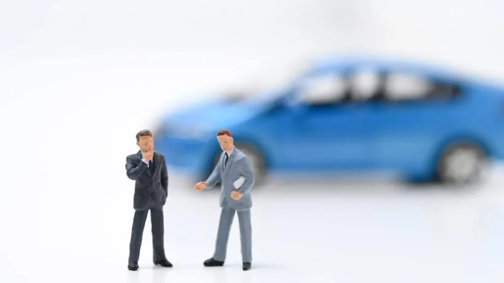 ミニカーを背景に話し合う人のオブジェ