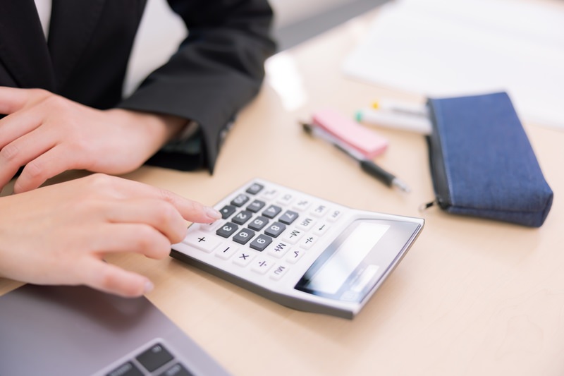 コストの比較を電卓で計算しているイメージ