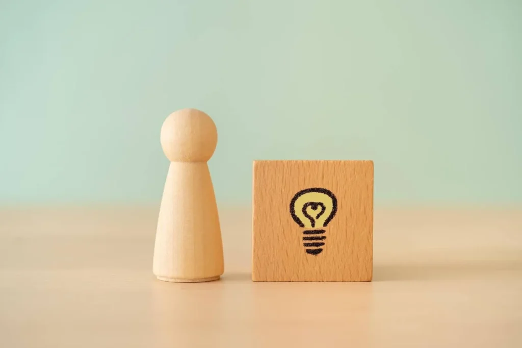 木製の人形と電球マークが書かれた積み木