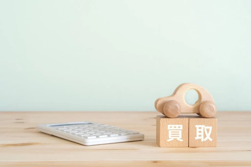 買取と書かれた積み木と木製の車や電卓