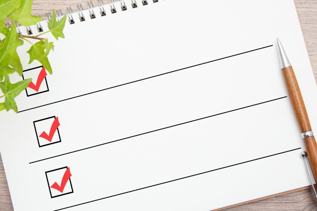 チェックリストが書かれたノートとペン