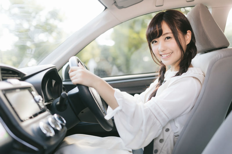 ハンドルを握りながらこちらを見てくる女性