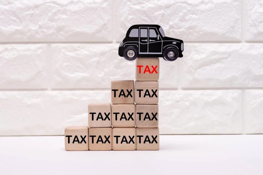 TAXと書かれた右肩上がりのブロックとミニカー